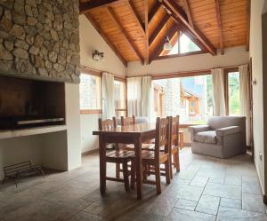 a dining room with a table and chairs and a couch at Ayelen Andina in Esquel
