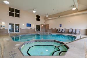 a large indoor pool in a large building with chairs at Days Inn & Suites by Wyndham Brandon in Brandon