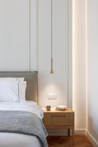 a bedroom with a bed and a wooden night stand at Heronia Suites in Karistos