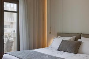 a bedroom with a bed and a window at Heronia Suites in Karistos +23 photos