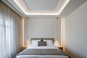 a bedroom with a bed and a large window at Heronia Suites in Karistos