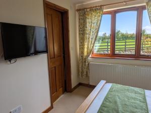 a bedroom with a flat screen tv and a bed at Sunset House in Penrith