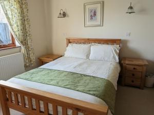 a bedroom with a large bed with a green blanket at Sunset House in Penrith +6 photos