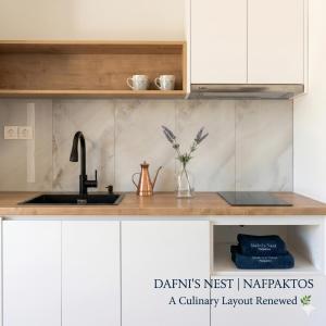 a kitchen with white cabinets and a sink at Dafni's Nest, Nafpaktos in Nafpaktos