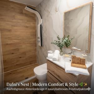 a bathroom with a sink and a toilet and a mirror at Dafni's Nest, Nafpaktos in Nafpaktos