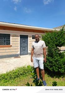 a man standing in front of a house at Hemison Homes in Naivasha
