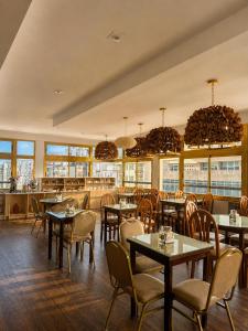 a restaurant with tables and chairs and windows at Hotel Valles in Mar del Plata