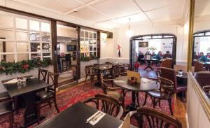 - un restaurant avec des tables, des chaises et des tables dans l'établissement The Beaufort Hotel, à Chepstow