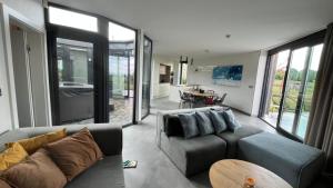 a living room with a gray couch and a kitchen at vila Kořenec in Kořenec
