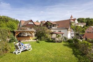 a yard with two lawn chairs and a house at Apartment-Haus Gundelfinger in Gräfenberg