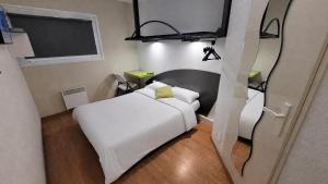 a bedroom with a white bed and a television at Good Night Hotel in Arques +40 photos