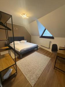 a attic bedroom with a bed and a window at Castle View Apartments in Făgăraş