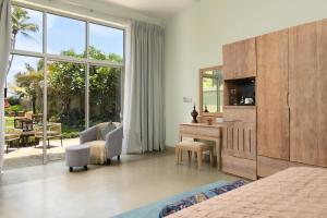 a bedroom with a bed and a desk with a tv at Ayuda Sanctuary Boutique Negombo in Negombo