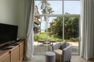 a living room with a large sliding glass door at Ayuda Sanctuary Boutique Negombo in Negombo