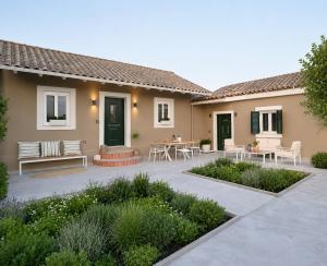 a patio of a house with a table and chairs at La casa di Antonio Corfu in Alepou