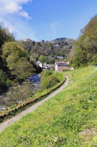 a dirt road next to a river in a field at The Rockford Inn in Lynton