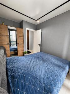 a bedroom with a blue comforter on a bed at Hostly, New Boulevard Prime Stay in Batumi