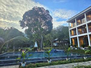 a resort with a swimming pool in front of a building at Meadow Mai Chau Homestay in Mai Châu