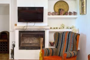 a living room with a fireplace with a television and a chair at VTAR CASILLA MIGUELIN in Montilla