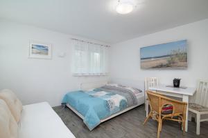 a bedroom with a bed and a desk and a table at Willa Di Mare in Karwia