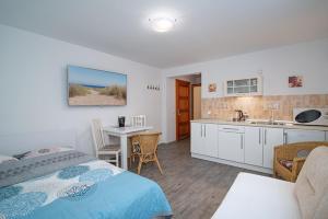 a bedroom with a bed and a kitchen at Willa Di Mare in Karwia