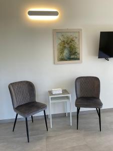 two chairs and a table in a room at Villa Franca in Pilzone