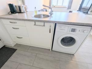 a kitchen with a sink and a washing machine at New Barnet Fresh Apartment in New Barnet