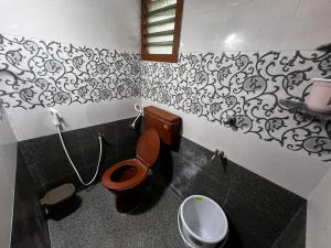 ein Badezimmer mit Toilette und Waschbecken in der Unterkunft Rivera inn in Tiruchirappalli