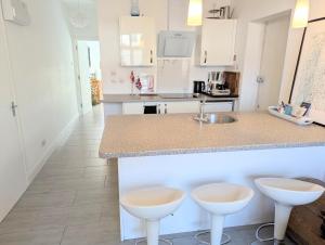 a kitchen with a counter and two stools at New Barnet Fresh Apartment in New Barnet +6 photos