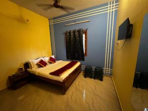ein Schlafzimmer mit einem Bett und einem Fernseher in der Unterkunft Rivera inn in Tiruchirappalli