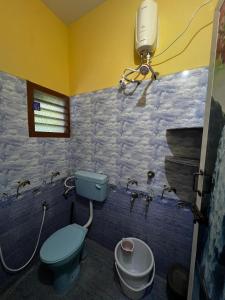 ein Badezimmer mit blauer Toilette und Licht in der Unterkunft Rivera inn in Tiruchirappalli