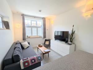 a living room with a couch and a flat screen tv at New Barnet Fresh Apartment in New Barnet