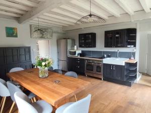 a large kitchen with a wooden table and chairs at Pallancheloc in Amions