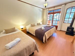 a bedroom with two beds and two windows at Hotel Naturaleza Vertientes de Elqui in El Molle +123 photos