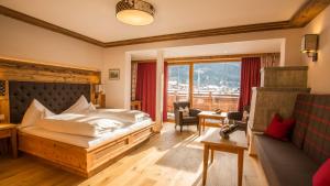 a bedroom with a bed and a living room at Hotel Spielmann 4s in Ehrwald +162 photos