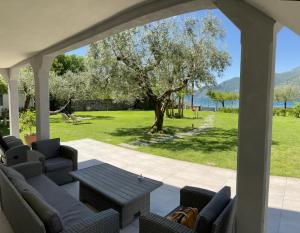 a patio with a table and chairs and a tree at Villa Franca in Pilzone