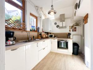 a kitchen with white cabinets and a sink at Logement entier hyper centre Chartres in Chartres