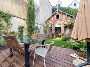 a patio with a glass table and chairs on a deck at Logement entier hyper centre Chartres in Chartres