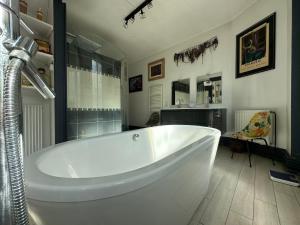 a large white tub in a bathroom with a window at Logement entier hyper centre Chartres in Chartres