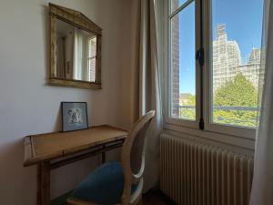 a desk with a chair next to a window at Logement entier hyper centre Chartres in Chartres +17 photos