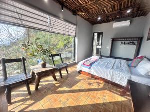 a bedroom with a bed and a large window at Villa Thẩm mã in Dồng Văn