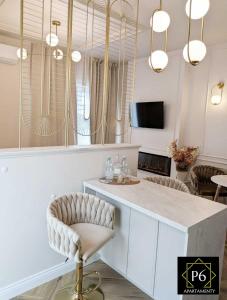 a kitchen with a counter with two stools in a room at P6 Apartament Kaszmirowy in Pisz