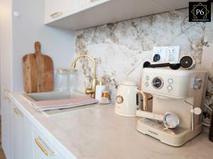 a kitchen counter with a coffee maker on it at P6 Apartament Kaszmirowy in Pisz