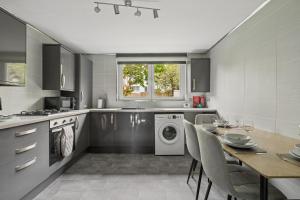 a kitchen with a washing machine and a table with chairs at The Glasgow Nook in Glasgow +33 photos