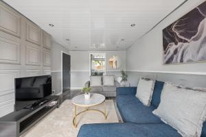 a living room with a blue couch and a tv at The Glasgow Nook in Glasgow