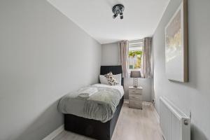 a small bedroom with a bed and a window at The Glasgow Nook in Glasgow