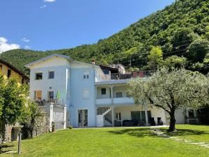 a large white house with a hill in the background at Villa Franca in Pilzone