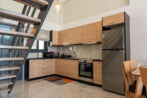 a kitchen with wooden cabinets and a stainless steel refrigerator at Evi Seaside Suites in Kanali