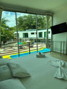 a bedroom with a large bed with a view of a pool at Hotel Cristalina in Melgar