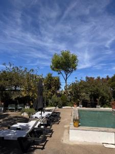 a row of tables and umbrellas next to a pool at Casa Melissa in Santo António do Baldio